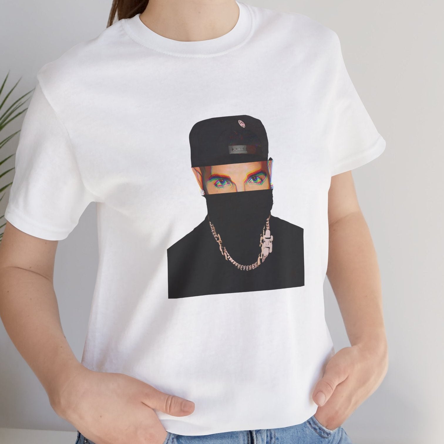 Canadian rapper music icon graphic t-shirt in white featuring illustrated silhouette portrait design with cap, chain necklace, and earring - styled by model in studio setting - modern design - IconBandwear music icons collection